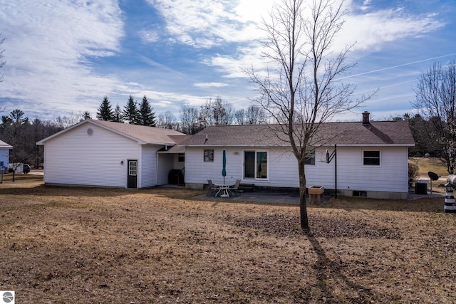 back of property with central air condition unit, a chimney, a patio, and roof with shingles