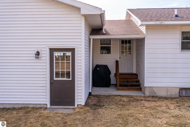 doorway to property featuring a shingled roof