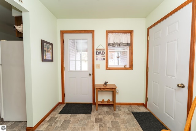 entryway featuring stone finish floor and baseboards