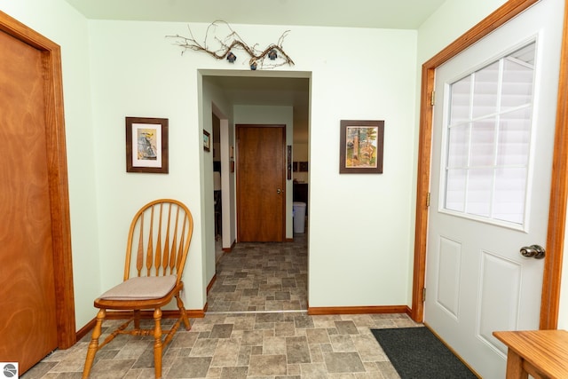 foyer entrance with baseboards and stone finish flooring