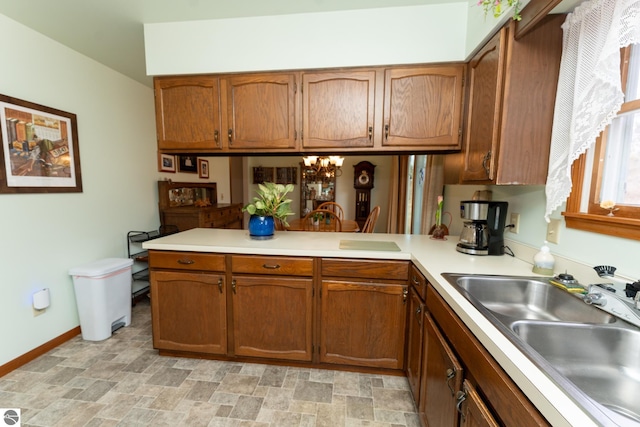 kitchen featuring brown cabinets, a peninsula, and light countertops