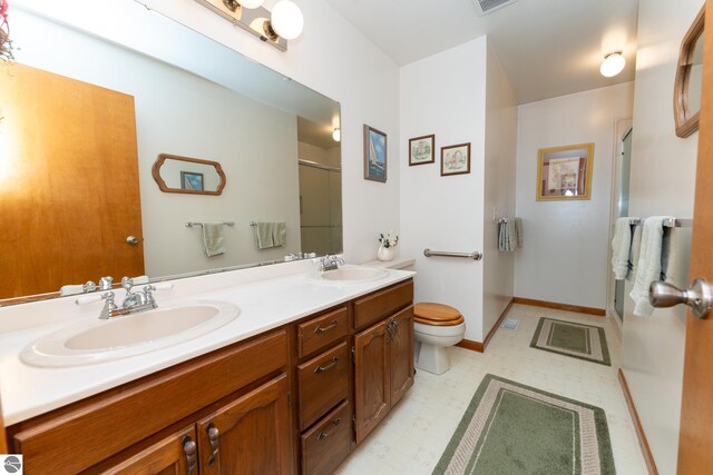 full bathroom with tile patterned floors, a stall shower, toilet, and a sink