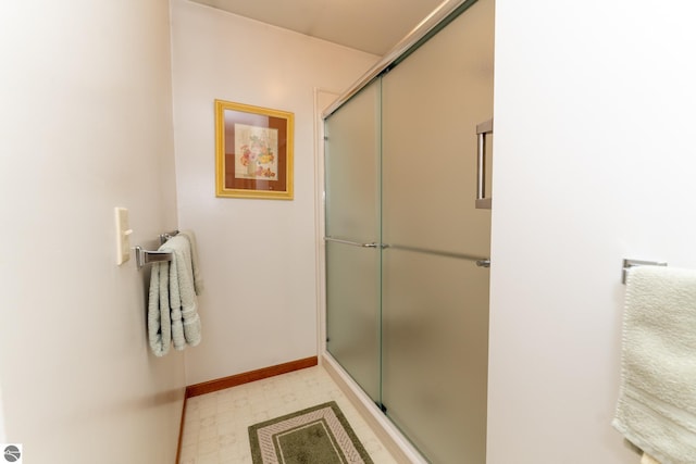 bathroom featuring tile patterned floors, baseboards, and a stall shower