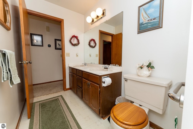 bathroom featuring tile patterned floors, toilet, baseboards, and a sink