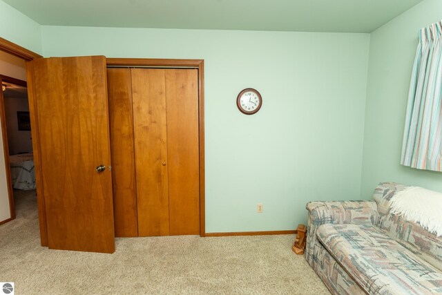 sitting room featuring carpet flooring and baseboards