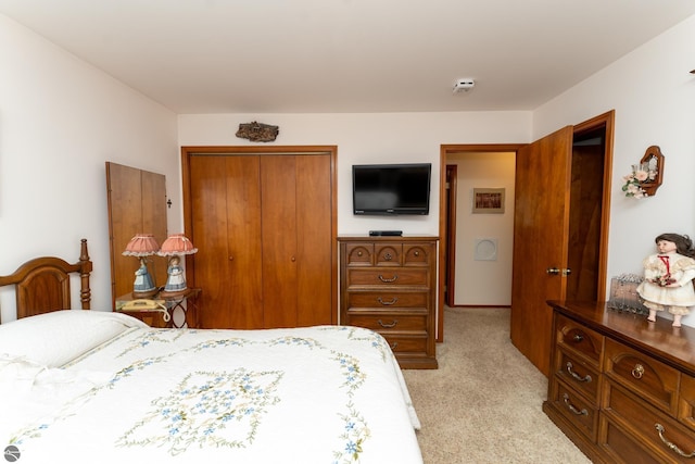 bedroom with a closet and light carpet