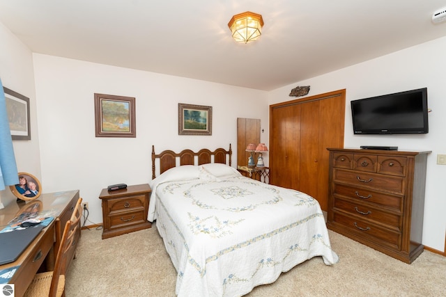 bedroom with light colored carpet, a closet, and baseboards