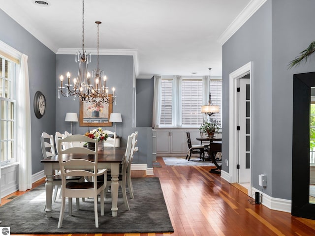 dining room featuring crown molding, baseboards, and wood-type flooring