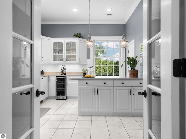 kitchen with glass insert cabinets, wine cooler, crown molding, and white cabinetry