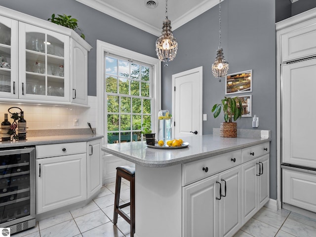 kitchen with beverage cooler, ornamental molding, light countertops, glass insert cabinets, and white cabinetry