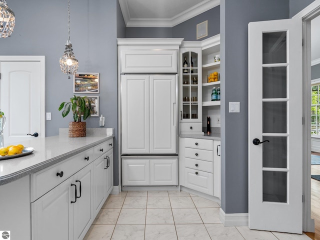 kitchen featuring marble finish floor, pendant lighting, white cabinetry, crown molding, and light countertops