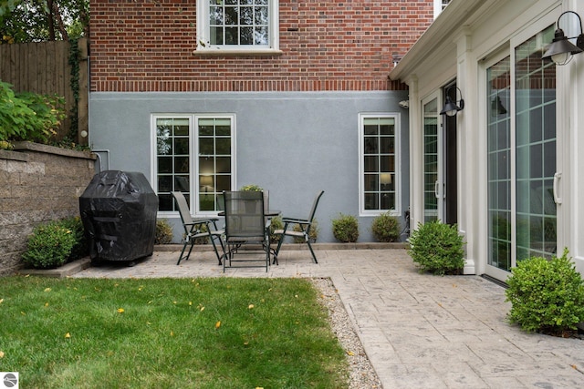 view of patio featuring a grill and fence