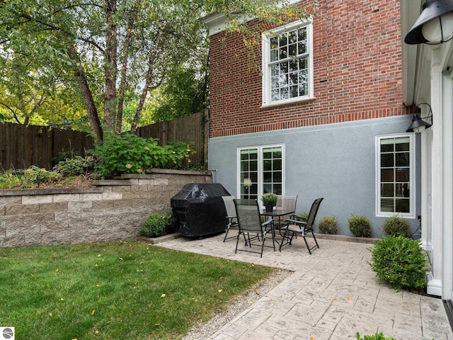 view of patio with area for grilling and fence