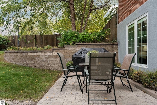 view of patio with outdoor dining space and fence