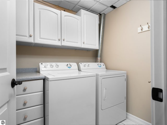 laundry area featuring baseboards, cabinet space, and washing machine and clothes dryer