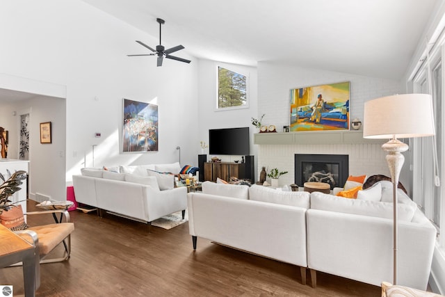 living area featuring a ceiling fan, high vaulted ceiling, dark wood-style flooring, and a fireplace