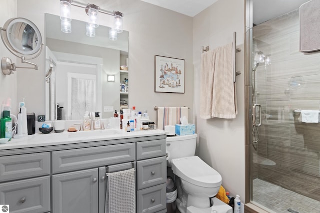 bathroom with toilet, a stall shower, and vanity