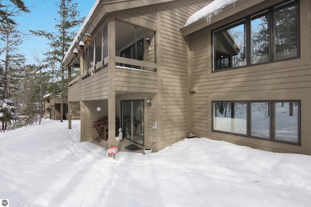 snow covered property featuring a balcony