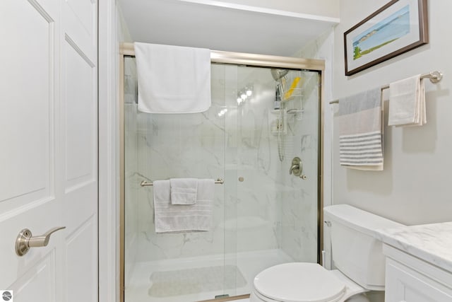 full bathroom featuring a marble finish shower, toilet, and vanity