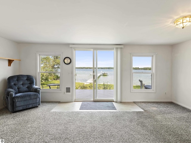 interior space featuring baseboards, a water view, and carpet flooring