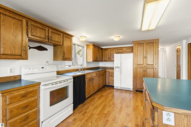 kitchen with dark countertops, light wood-type flooring, brown cabinetry, white appliances, and a sink