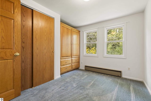 unfurnished bedroom featuring baseboard heating, carpet flooring, and baseboards