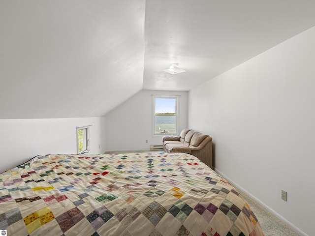 carpeted bedroom featuring a baseboard heating unit, vaulted ceiling, and baseboards