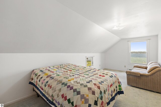 bedroom with light colored carpet, baseboards, and lofted ceiling