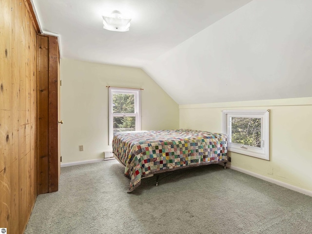 bedroom featuring a baseboard heating unit, lofted ceiling, baseboards, and carpet floors