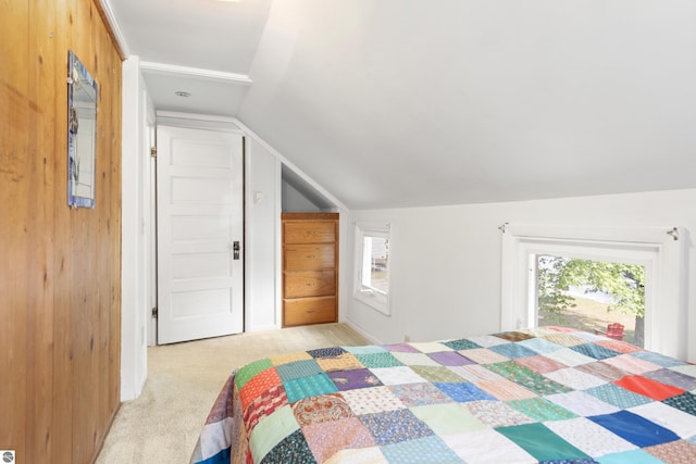 bedroom with vaulted ceiling, multiple windows, and light colored carpet