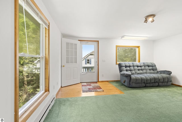 carpeted foyer entrance with a baseboard heating unit and baseboards