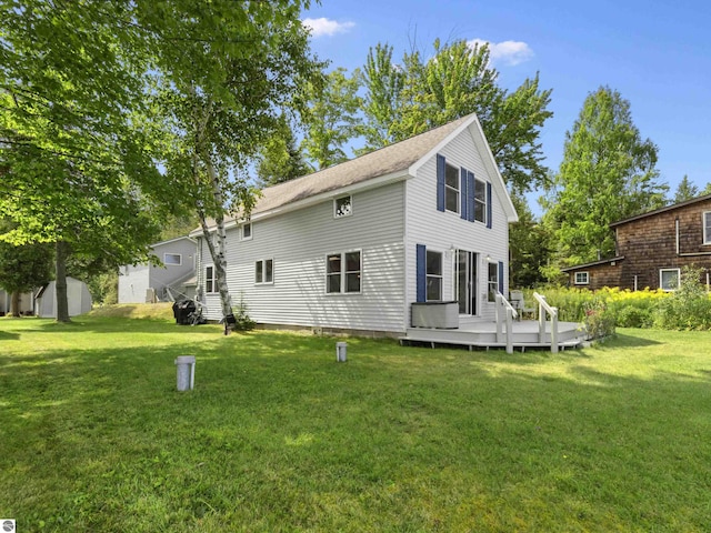 rear view of property featuring a lawn and a wooden deck