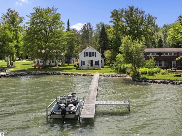 dock area featuring boat lift, a yard, and a water view