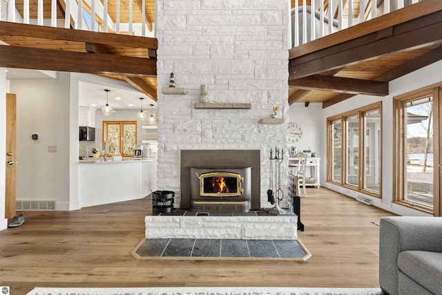 living room with beam ceiling, wood finished floors, and visible vents