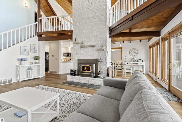 living area with wood finished floors, visible vents, high vaulted ceiling, beam ceiling, and wooden ceiling