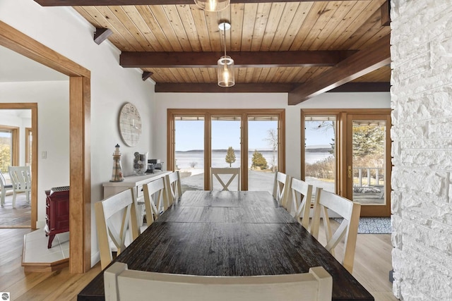 unfurnished dining area featuring a wealth of natural light, beam ceiling, wooden ceiling, and light wood-style floors