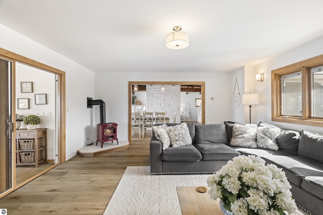 living room featuring a wood stove, wood finished floors, and baseboards