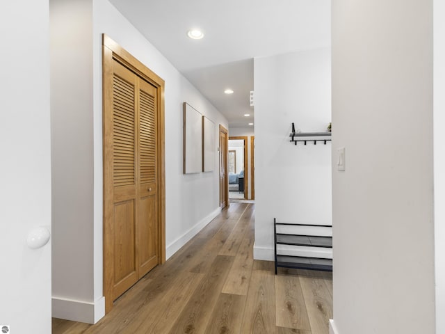 corridor featuring recessed lighting, baseboards, and light wood finished floors