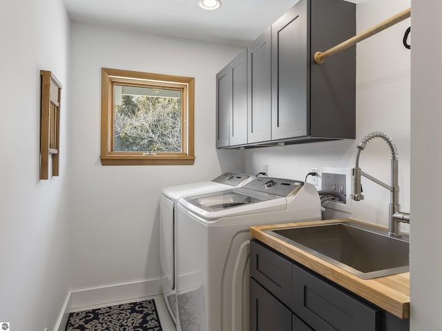 laundry room with baseboards, cabinet space, a sink, tile patterned floors, and washer and clothes dryer