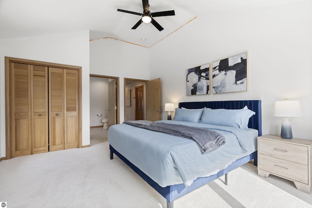 bedroom with light carpet, a ceiling fan, lofted ceiling, and ensuite bathroom