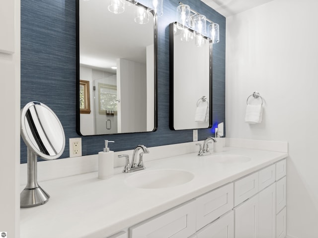 full bathroom featuring double vanity, a stall shower, and a sink