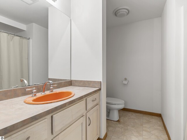 bathroom with visible vents, toilet, a shower with shower curtain, baseboards, and vanity