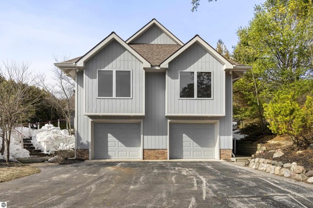 view of front of house with a garage, a shingled roof, and aphalt driveway