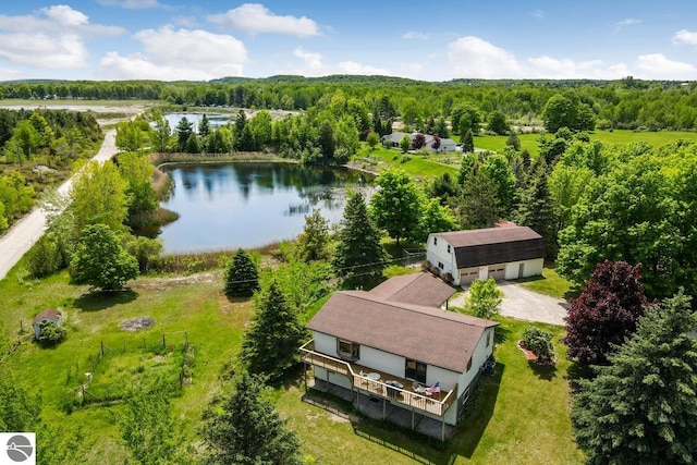 birds eye view of property featuring a wooded view and a water view