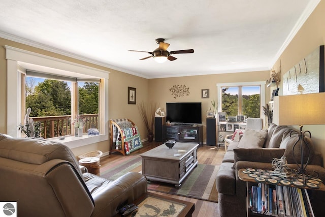 living area with crown molding, ceiling fan, and wood finished floors