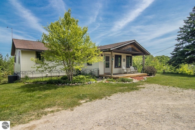 back of property featuring a porch, a lawn, central AC, and roof with shingles