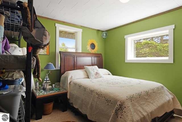 bedroom featuring multiple windows, carpet, and ornamental molding