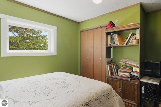 bedroom featuring crown molding and a closet