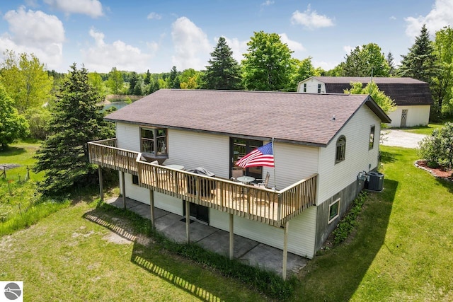 rear view of house featuring cooling unit, a yard, roof with shingles, and a wooden deck