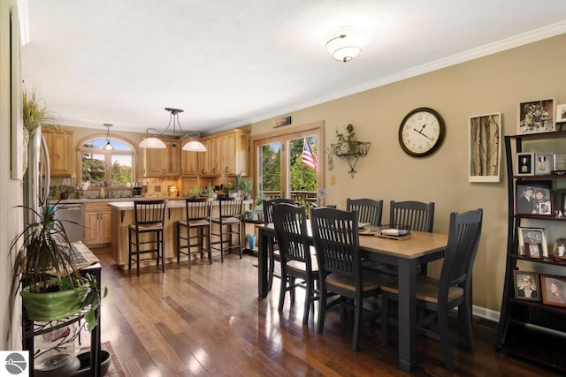 dining room featuring baseboards, dark wood finished floors, and ornamental molding